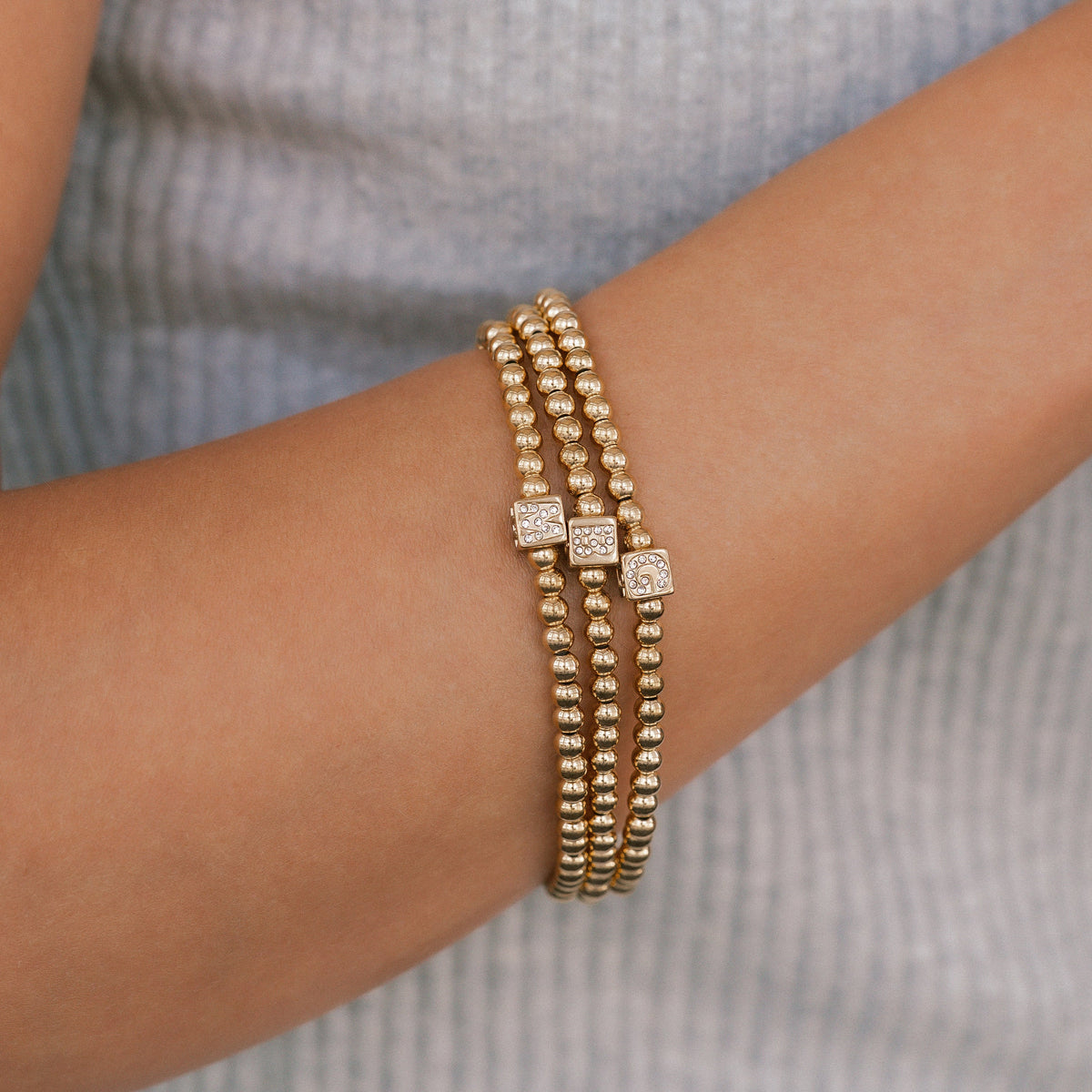 Bracciale con iniziale a blocchi e perline dorate