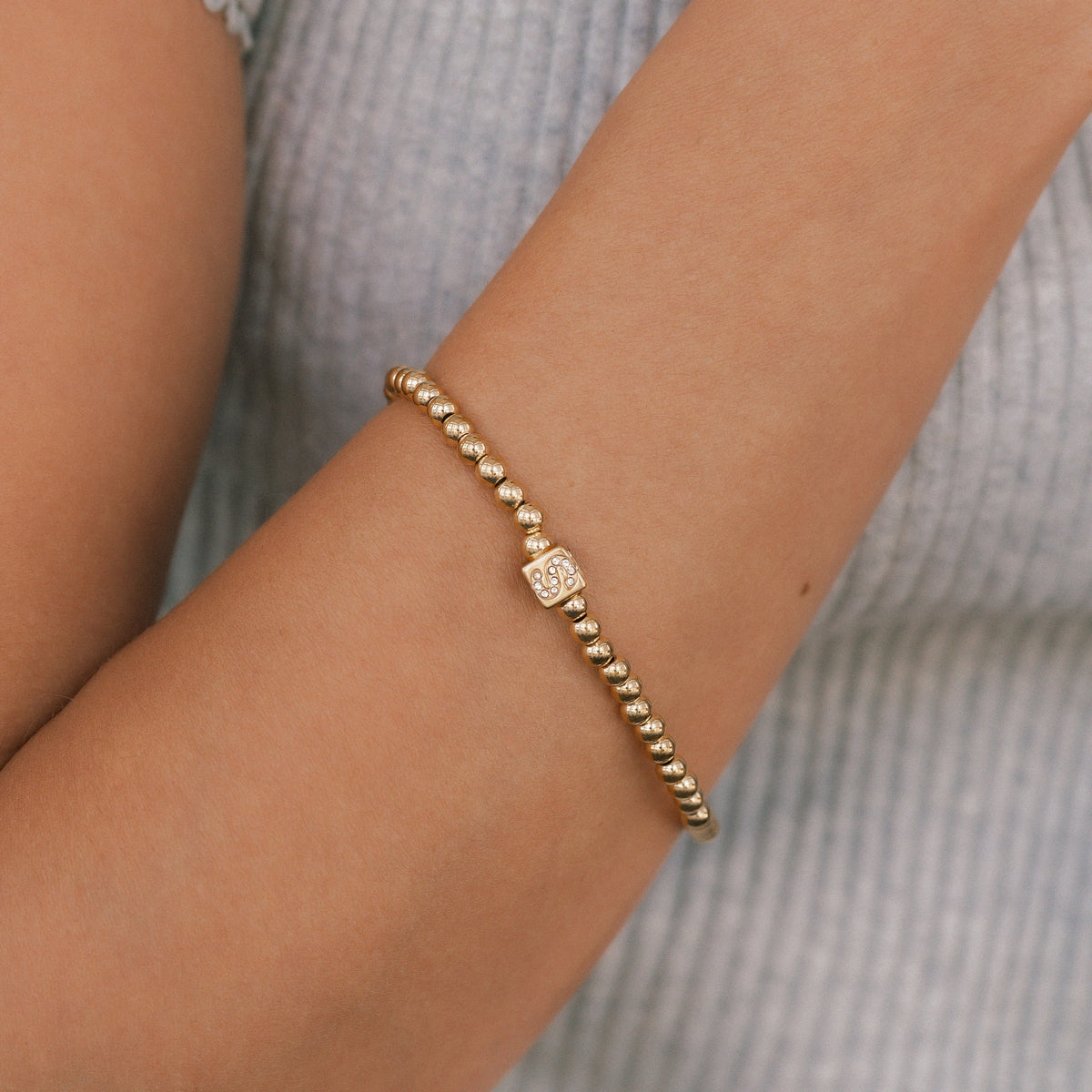 Bracciale con iniziale a blocchi e perline dorate