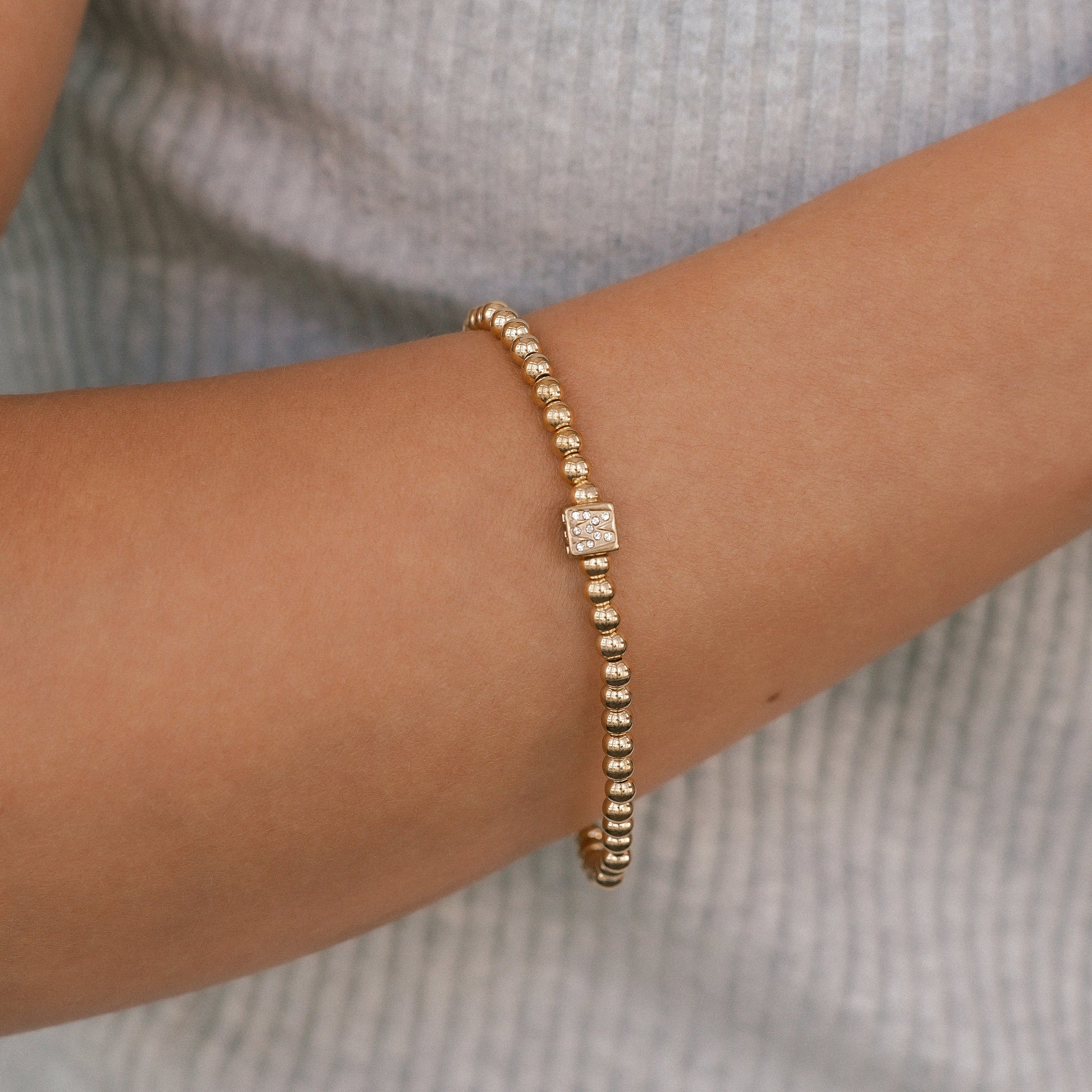 Bracciale con iniziale a blocchi e perline dorate