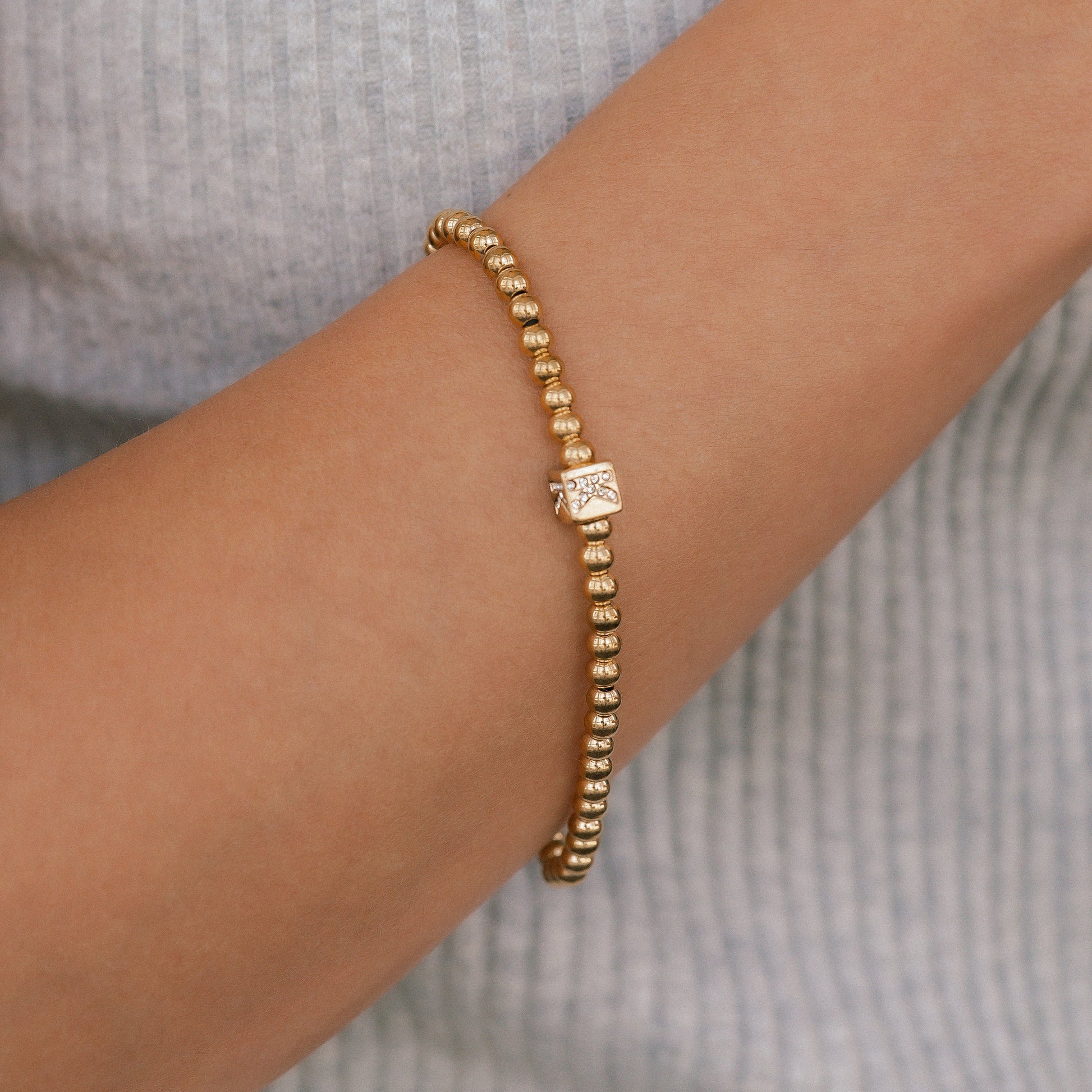 Bracciale con iniziale a blocchi e perline dorate