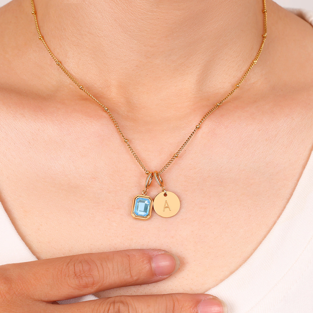 Collana con baguette, pietra portafortuna e iniziale