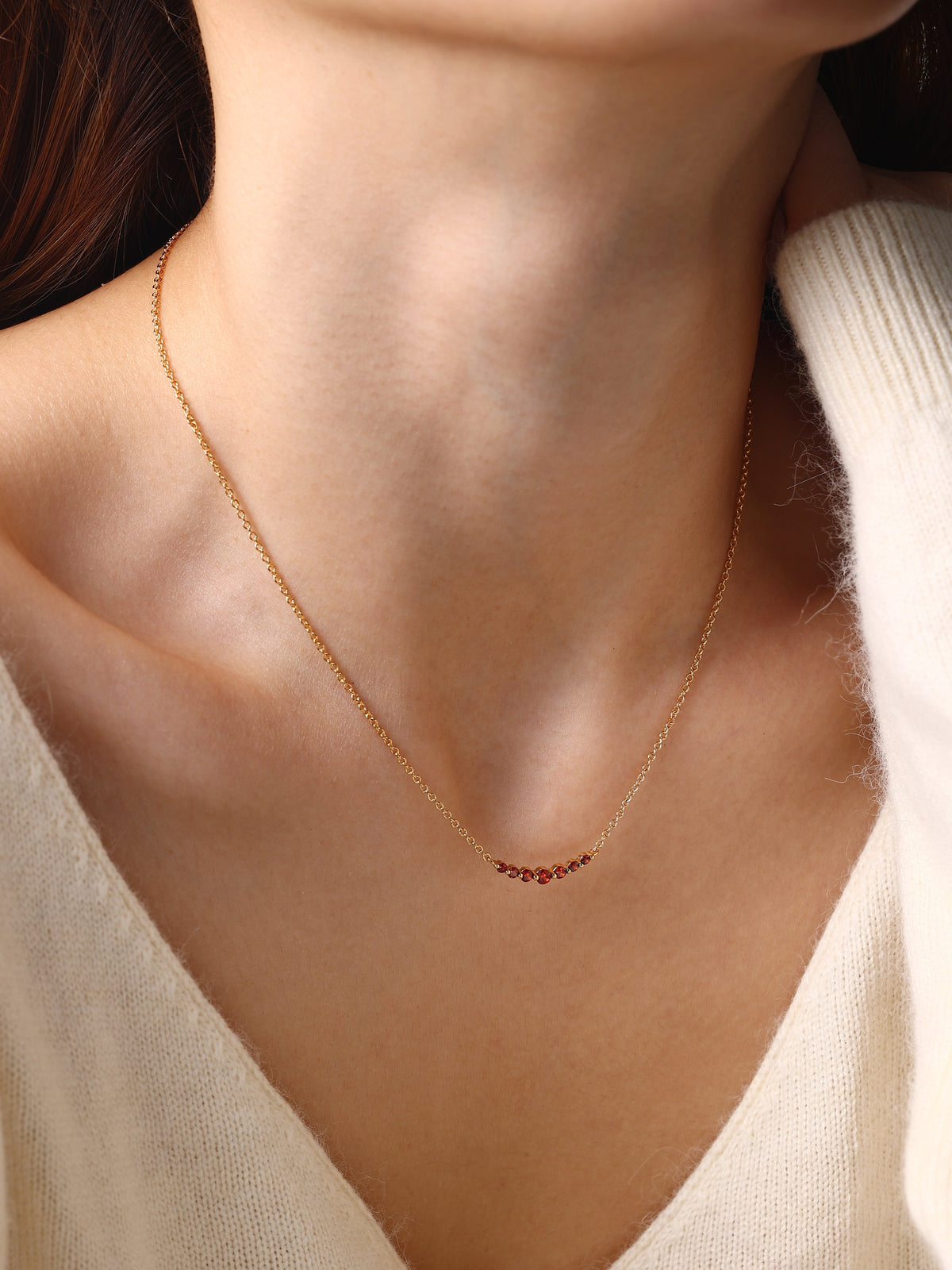 Birthstone Arc Necklace with January birthstone, worn on a model