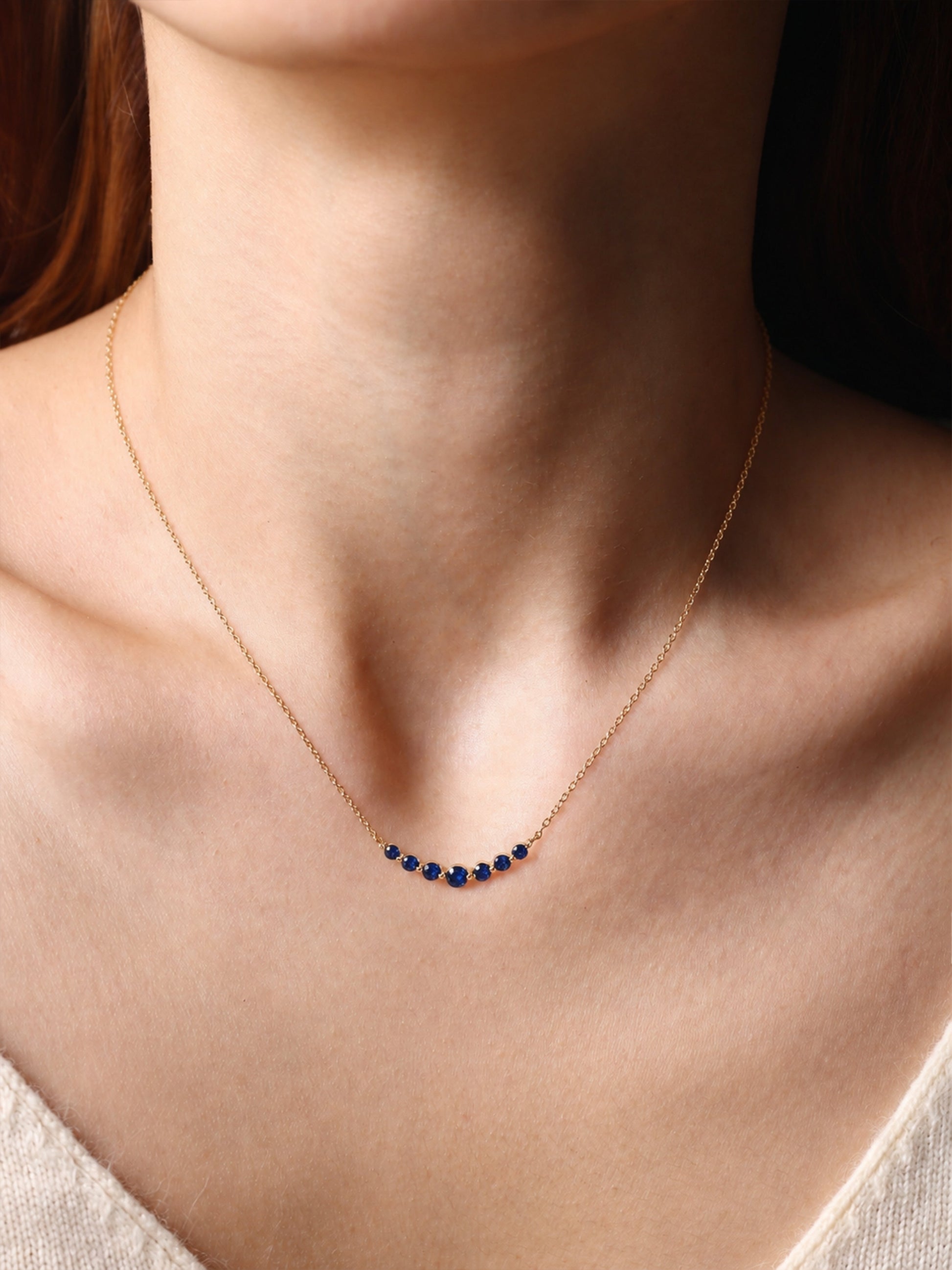 Birthstone Arc Necklace with September birthstone, worn on a model