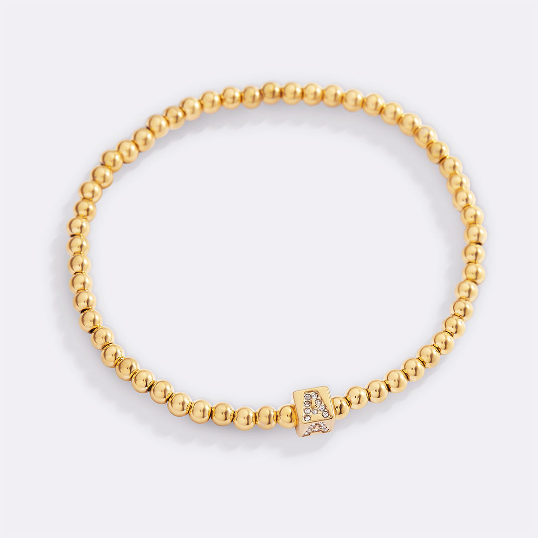 Bracciale con iniziale a blocchi e perline dorate
