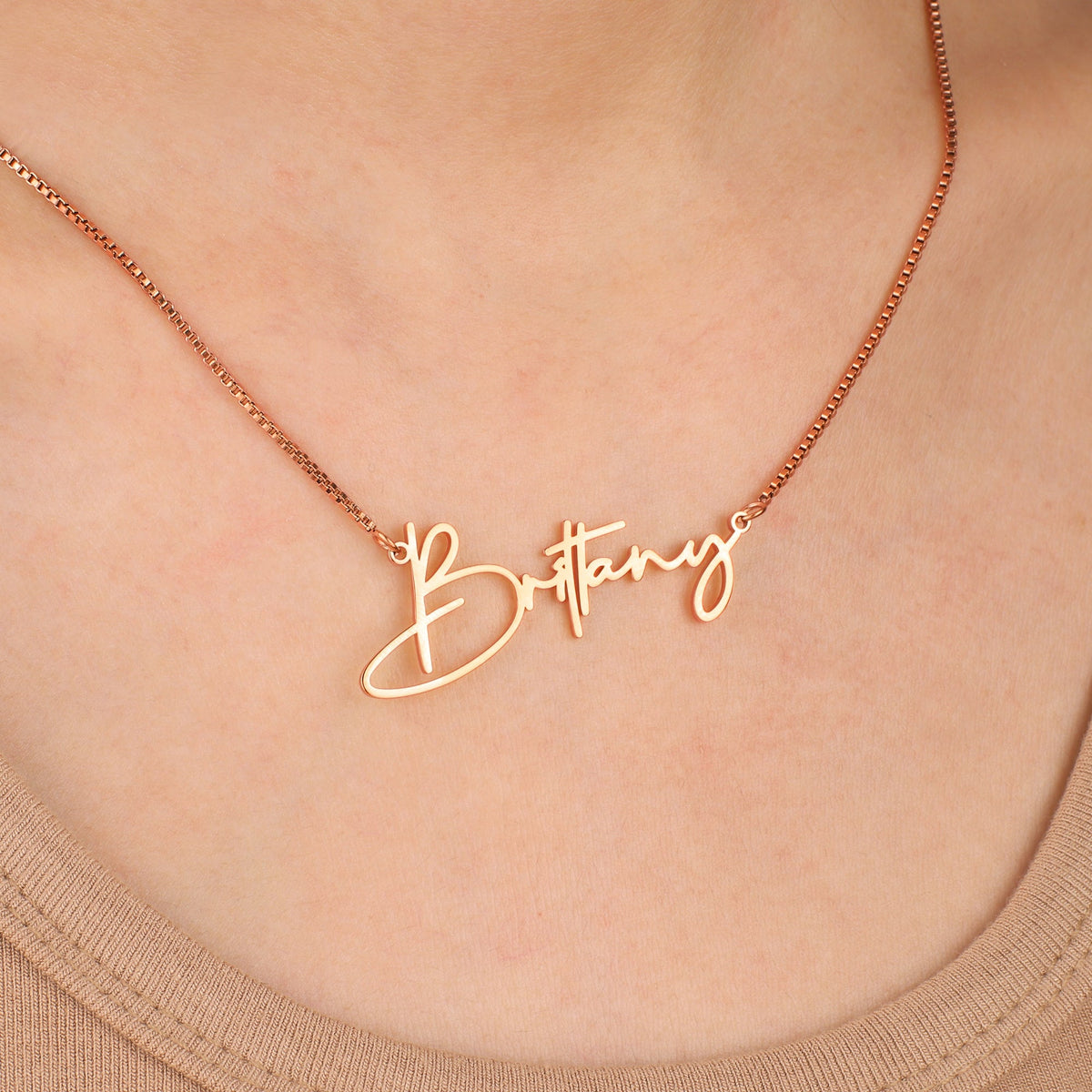Modern Name Necklace in rose gold tone, worn on a model