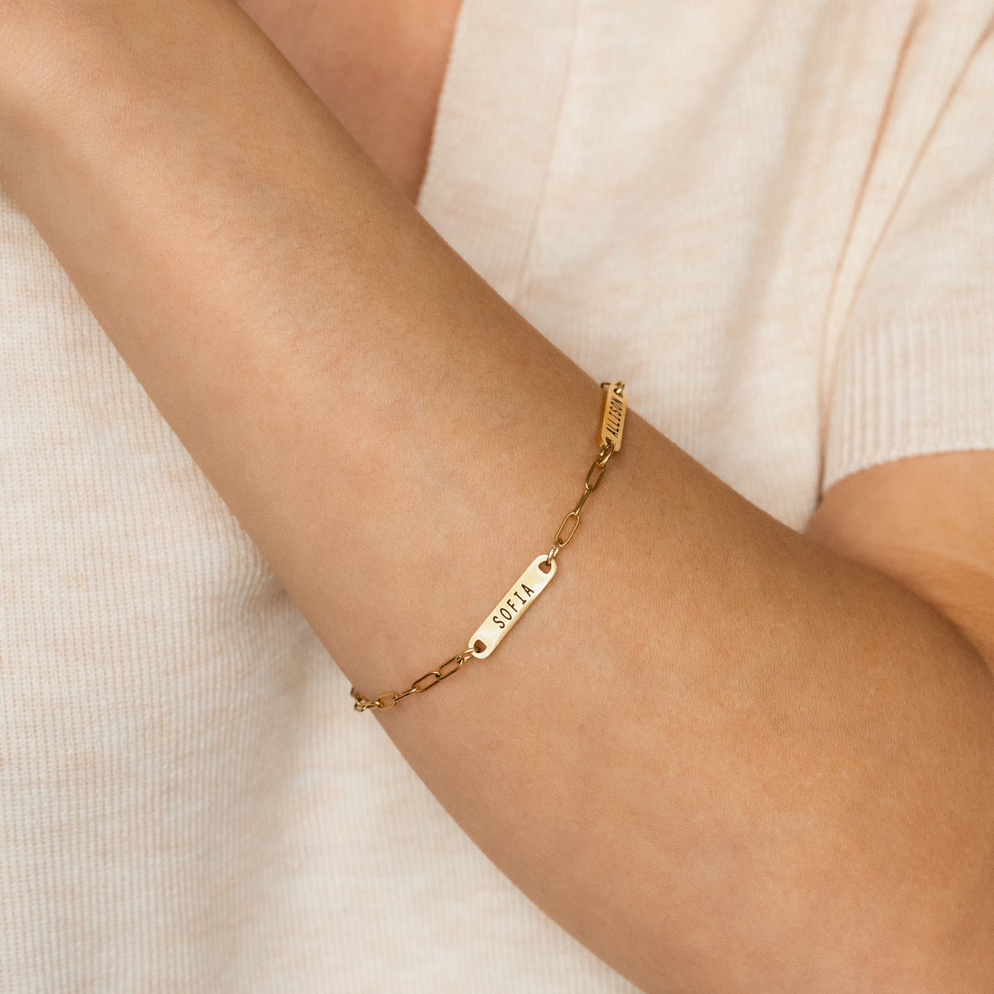 Personalized Paperclip Name Bracelet in gold tone, worn on a model