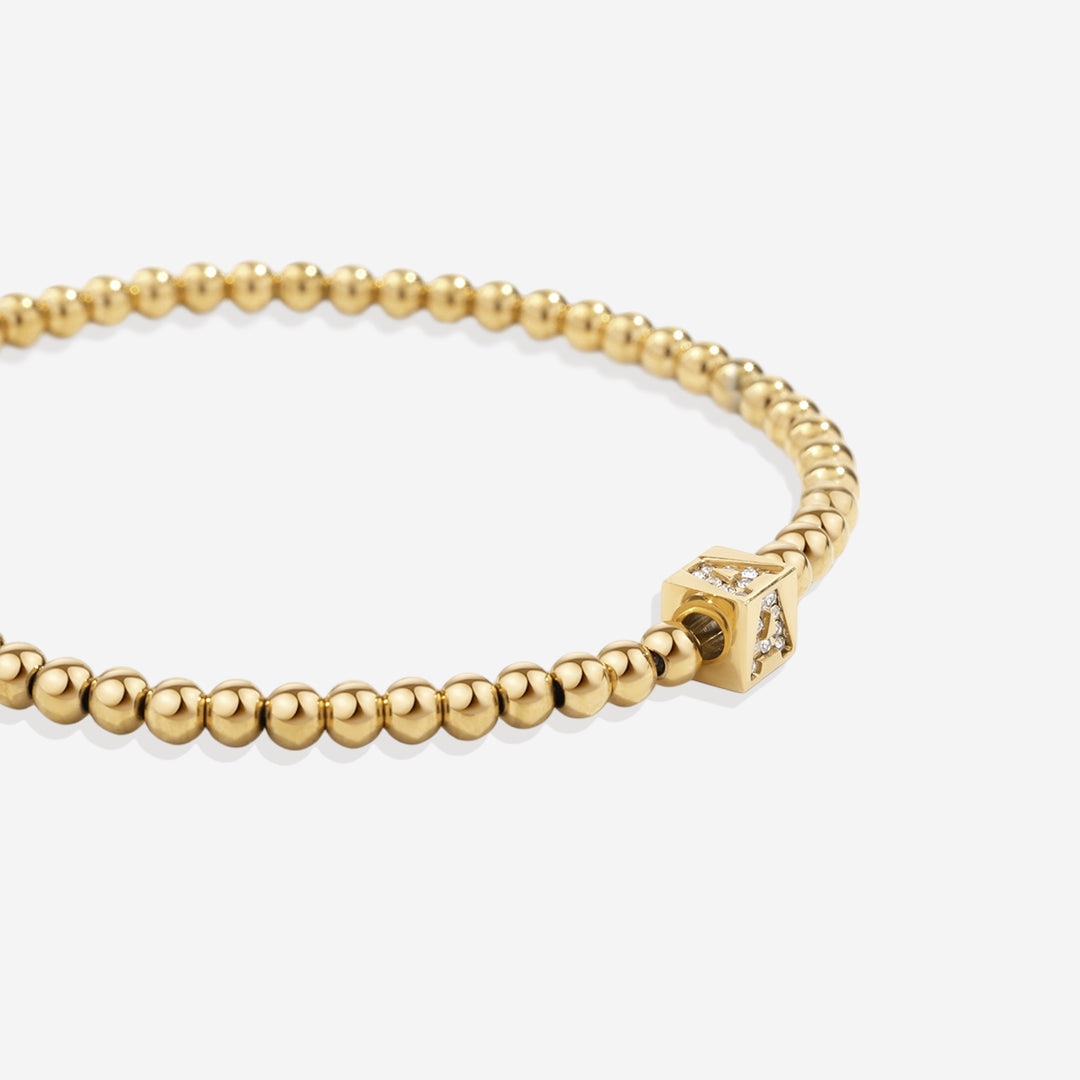 Bracciale con iniziale a blocchi e perline dorate