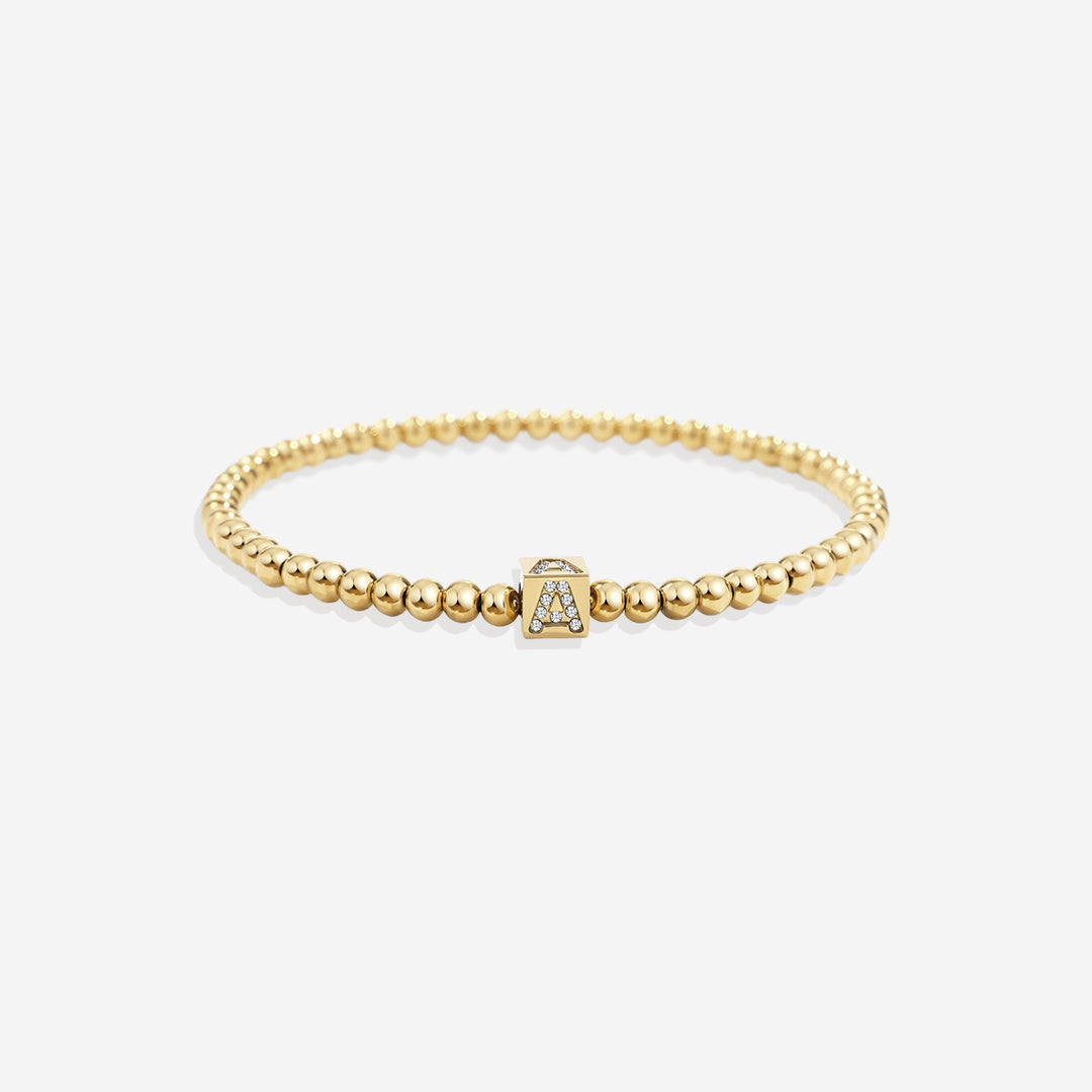 Bracciale con iniziale a blocchi e perline dorate