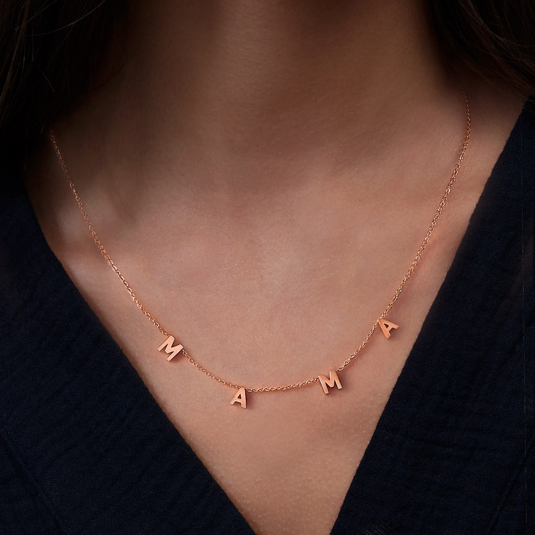 The MAMA Letter Necklace in rose gold tone, worn on a model
